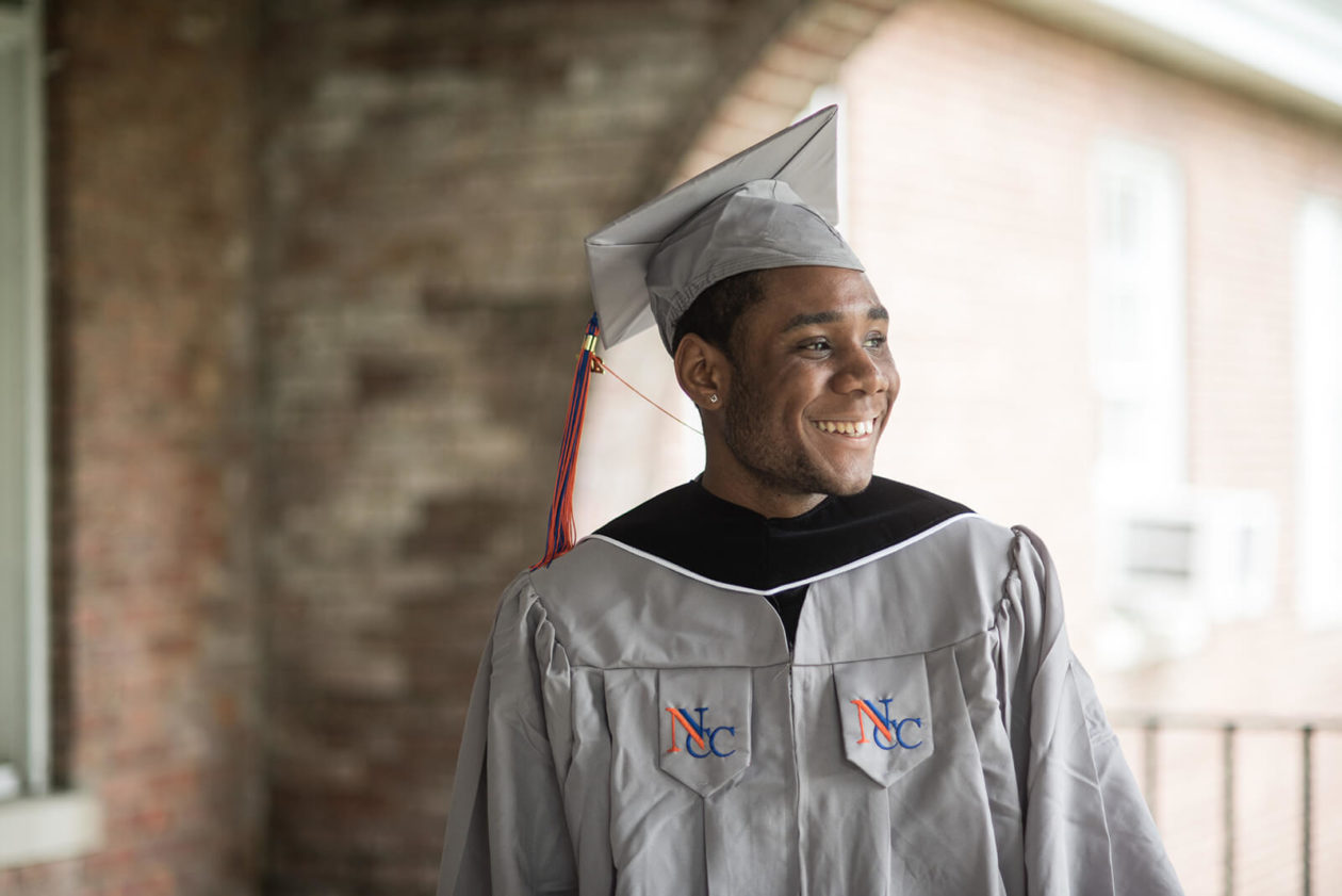 Young college graduate in a gray cap and gown.