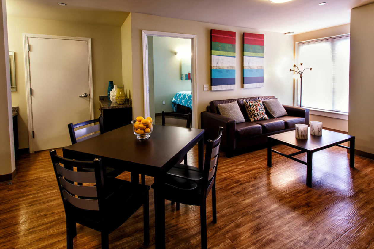 Interior of college student housing with table and couch.